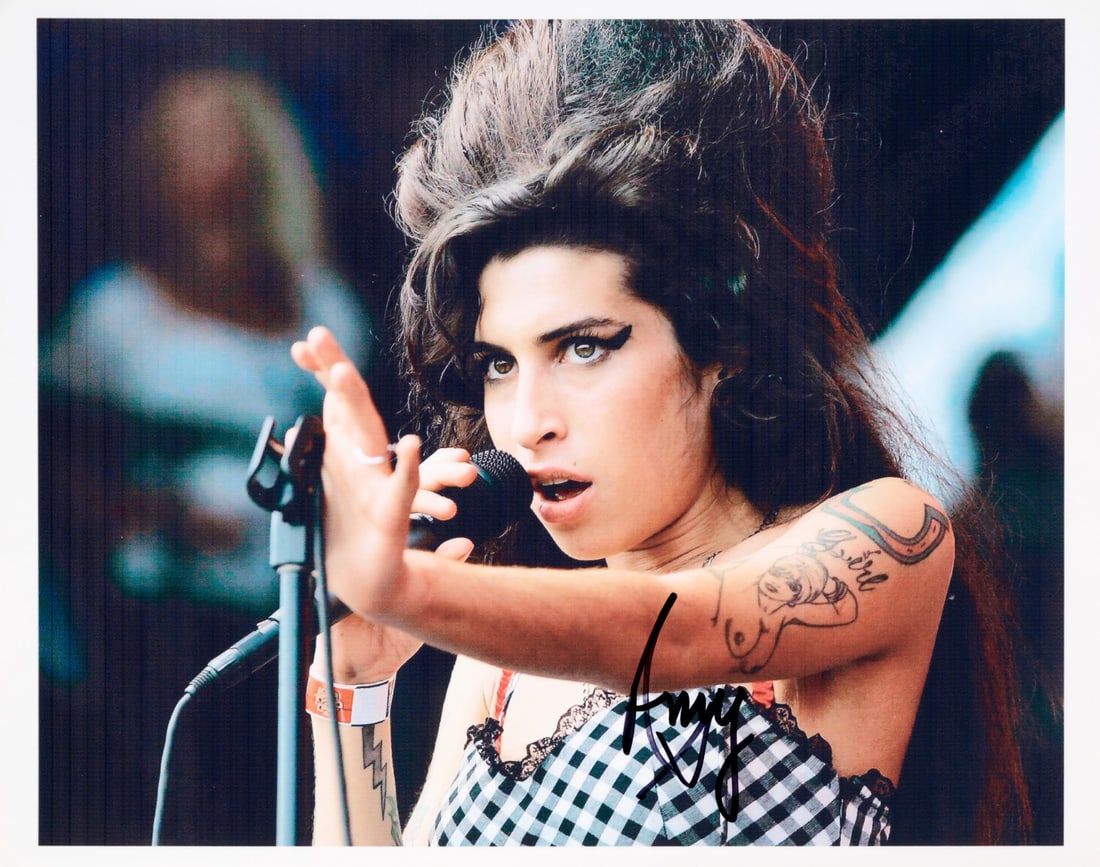 AMY WINEHOUSE Signed photographic print: Signed photographic print depicting the artist in concert 8.46 x 11.02 in.