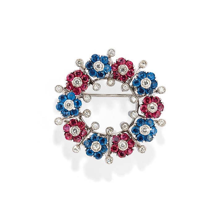 SPILLA IN DIAMANTI E GEMME - DIAMOND AND GEM-SET BROOCH: in oro bianco 18 kt a forma di ghirlanda con fiori "en tremblant" in corindoni e diamanti. Circa 1970. Gr 12,60 - cm 3,10 x 3,00 - designed as an 18K white gold wreath with "en tremblant" flowers in c