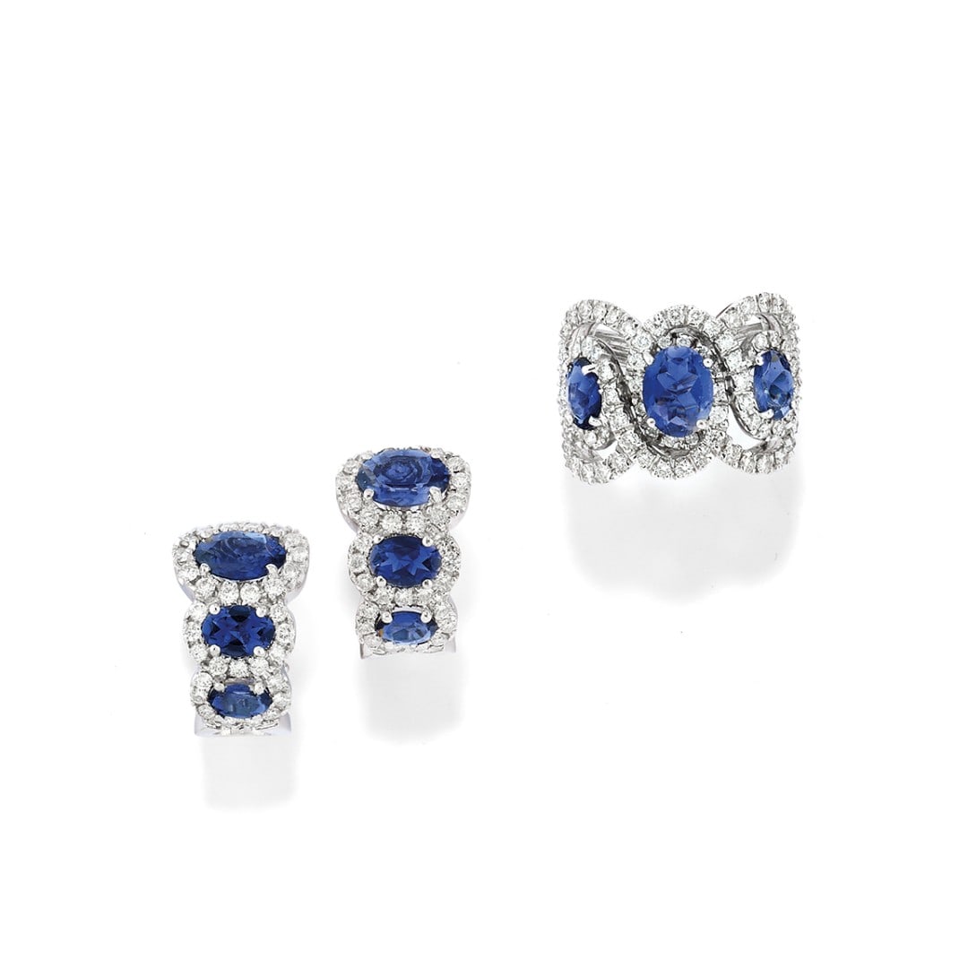 DEMI-PARURE IN IOLITE E DIAMANTI - IOLITE AND DIAMOND DEMI-PARURE: in oro bianco 18 kt, composta da un anello a volute in diamanti che trattengono tre iolite e da un paio di orecchini con tre iolite a scalare contornati da diamanti. Gli orecchini con chiusura a clip 