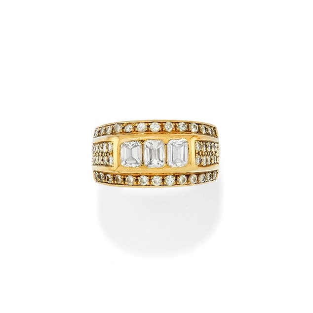ANELLO IN DIAMANTI - DIAMOND RING: in oro giallo 18 kt, con tre diamanti taglio smeraldo di ct 1,00 ca. complessivi contornati da pav? di diamanti di ct 0,50 ca. complessivi. Circa 1970. Gr 9,20 - cm 1,20 - nr 16,5 - in 18K yellow gold