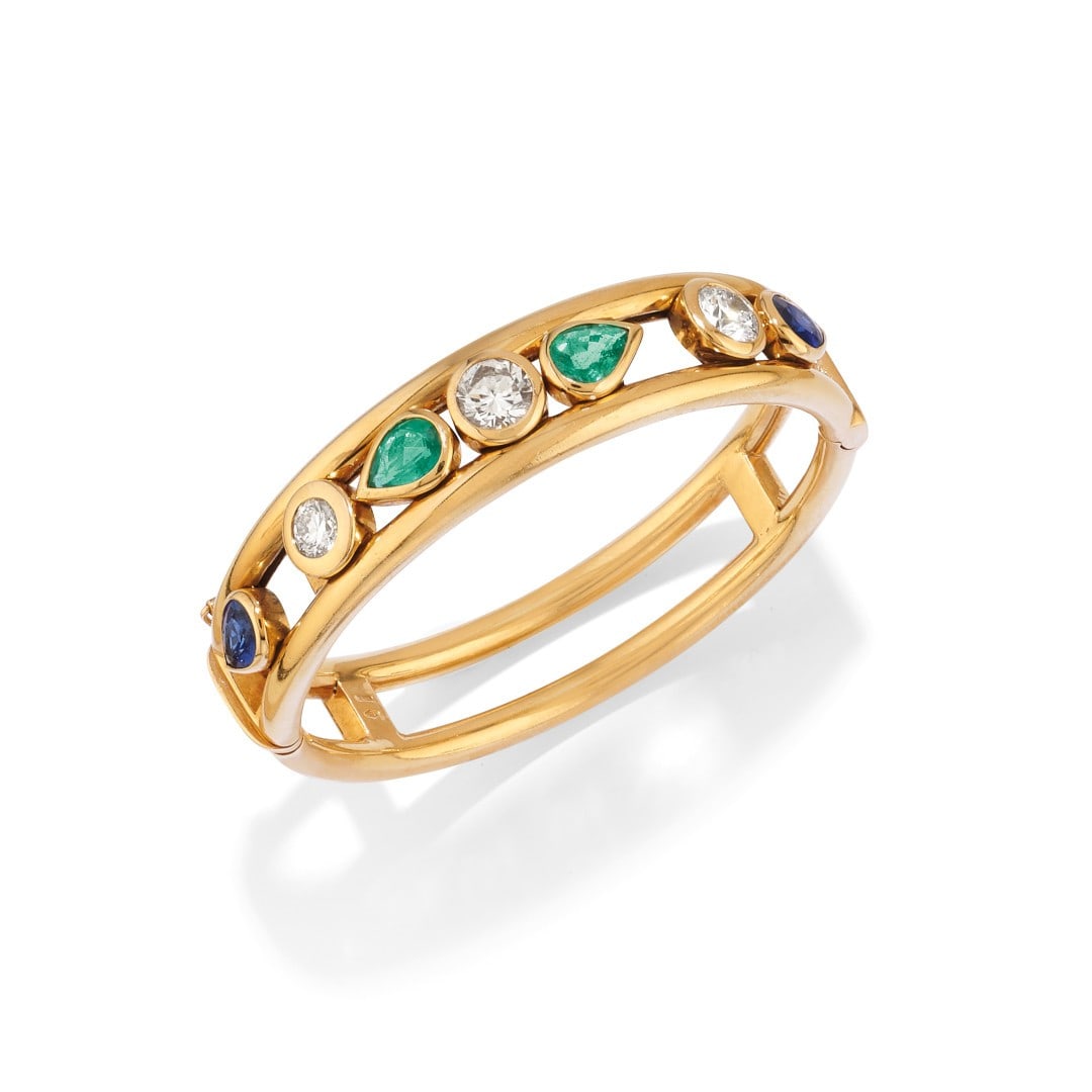 BRACCIALE RIGIDO IN DIAMANTI, ZAFFIRI E SMERALDI - DIAMOND, SAPPHIRE AND EMERALD BANGLE: in oro giallo 18 kt eseguito a canna doppia con gocce di smeraldi e zaffiri e diamanti in castoni rotondi. Gr 47,30 - cm 16,00 x 1,30 - designed as double 18K yellow gold canes with emerald and sapphi
