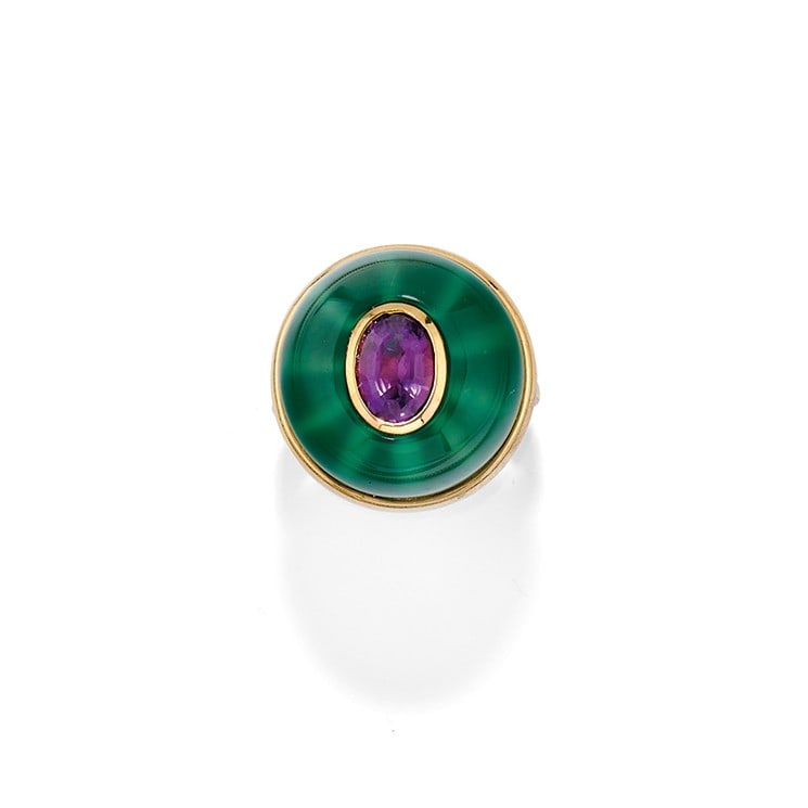 ANELLO IN AMETISTA - AMETHYST RING: in oro giallo 18 kt a cupola con una pasta vitrea verde centrata da un'ametista. Circa 2000. Gr 18,00 - diam cm 2,00 - nr 15 - in 18K yellow gold, designed as a dome with a green paste centred by an a
