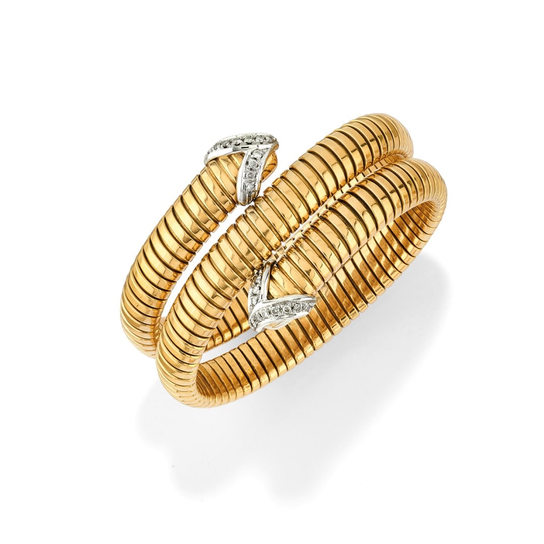 BRACCIALE IN ORO GIALLO 18 KT - 18K YELLOW GOLD BRACELET: realizzato a maglia tubogas a contrari? terminante con due punte in oro bianco 18 kt ornate da diamanti.?Circa 1960. Gr 99,80 - cm 16,00 x 3,50 - designed as a tubogas band with crossover design endin