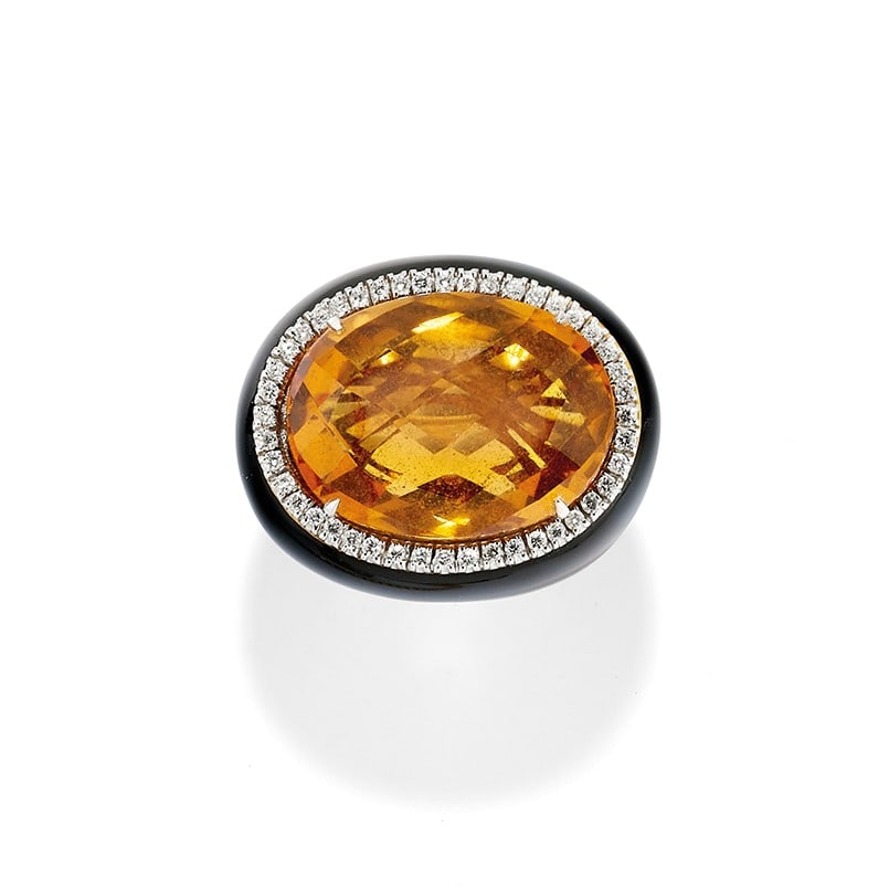 ANELLO IN QUARZO CITRINO, SMALTO NERO E DIAMANTI - CITRINE QUARTZ, BLACK ENAMEL AND DIAMOND RING: in oro giallo 18 kt, con gambo a fascia larga in smalto nero con diamantini che abbracciano un quarzo citrino?briolette di ct 30,00 ca. Circa 2000. Gr 30,80 - cm 2,50 - nr 12,5 - in 18K yellow gold, w