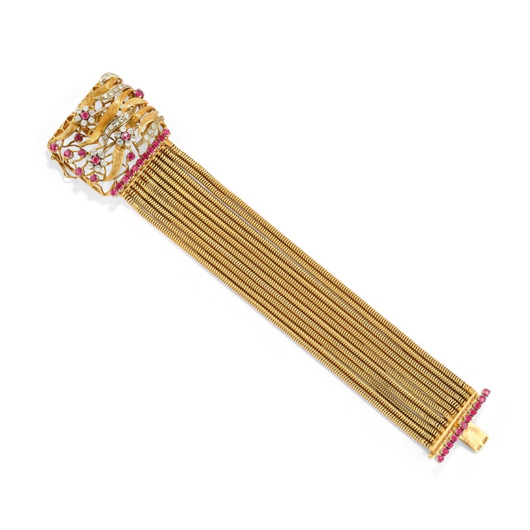 BRACCIALE IN DIAMANTI E CORINDONI - DIAMOND AND CORUNDUM BRACELET: in oro giallo 18 kt a undici fili con chiusura rettangolare con motivo floreale in diamanti e corindoni rossi. Circa 1940. Gr 61,50 - cm 15,70 x 3,40 - in 18K yellow gold, designed as eleven strands w