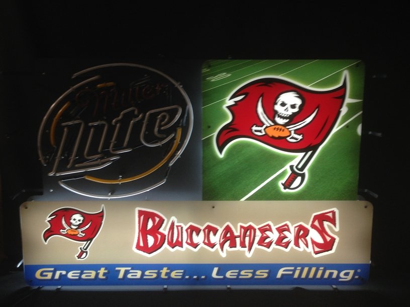 Neon Sign Miller Lite and Tampa Bay Buccaneers: Working bright neon sign measures approximately 43" across and 27" tall. The sign can stand on it's own, or it can be hung. Fantastic piece of advertising neon art...shipping must be arranged by the w
