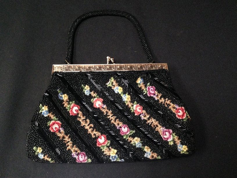 Vintage Beaded and Petit Point Evening Bag.: Next on the block is this vintage mid-century black beaded and floral petit point evening bag. The purse has black seed beads and bugle beads and a gold tone frame and a single beaded hand strap. It m