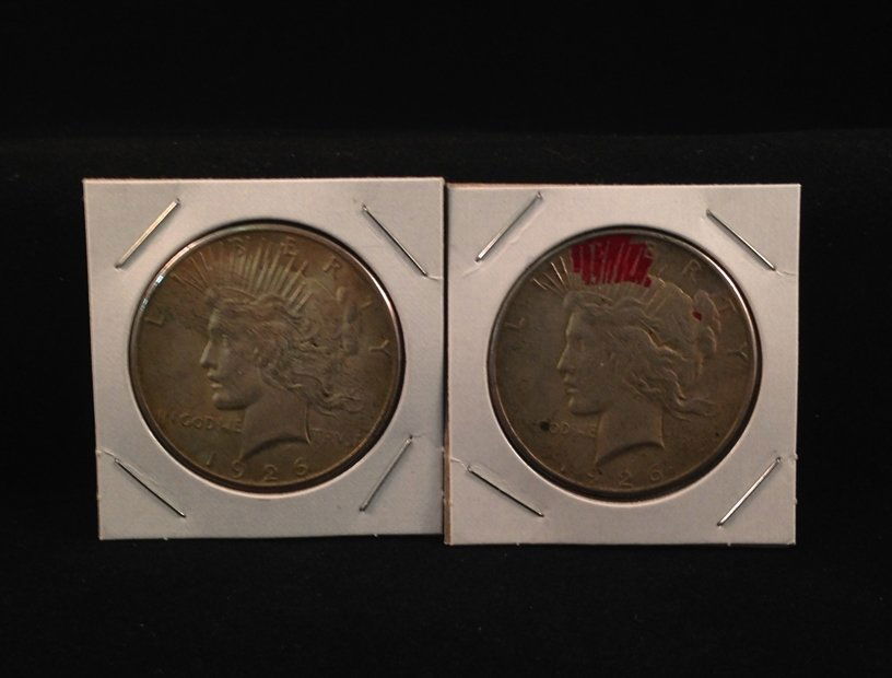 Lot of (2) 1926 S Peace Silver Dollars: Nicer coins. One coin has a red ink stain on the obverse. The other looks like it may have been taped in a binder as there appears to be adhesive residue across the obverse. Both coins are well struck