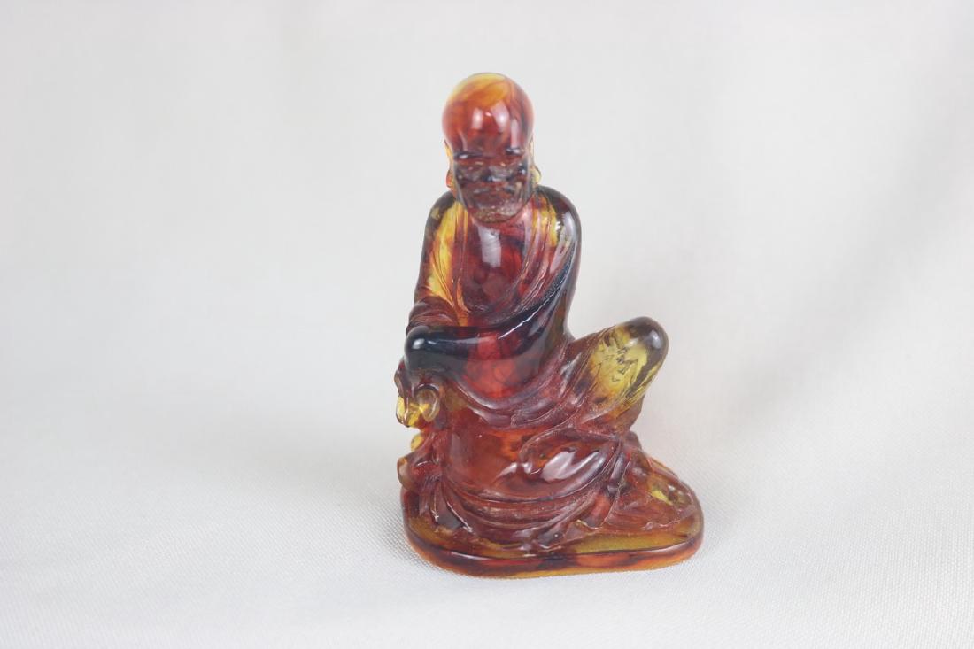 Chinese Carved Amber Luo Han: Chinese carved amber Luo Han; both hands resting on his knee; seating form; H: 8 cm, W: 5.5 cm