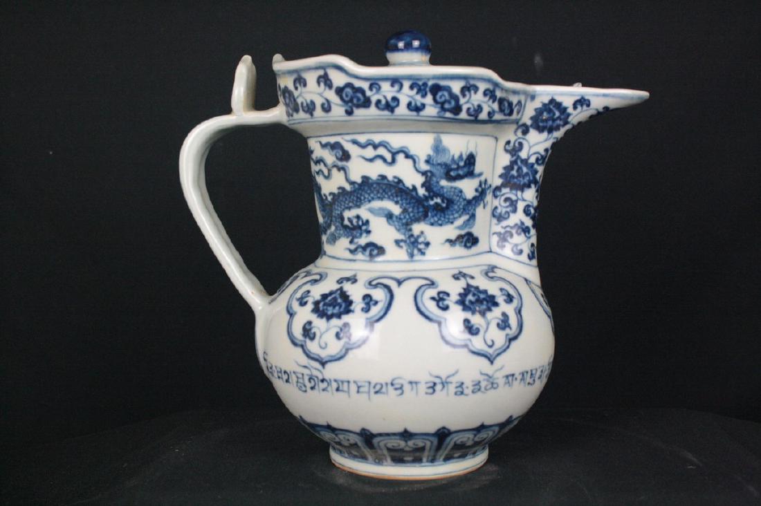 Chinese Blue and White Porcelain Ewer: Chinese blue and white porcelain ewer; flanked by curved handle and spout; painted with leafy scrolls and dragon; four character Xuande mark on base; H: 23 cm, W: 25 cm