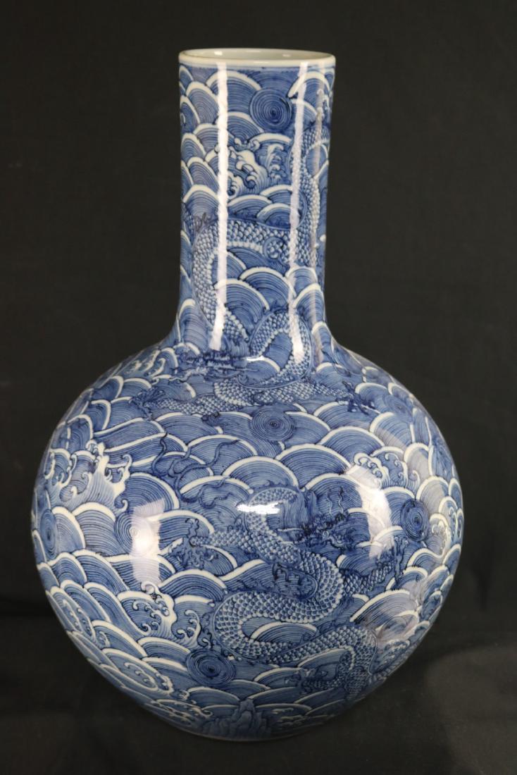 Chinese Blue and White Porcelain Vase: Chinese blue and white porcelain vase; body of rotund shape; painted with dragon surrounded by stormy waves; six character Qianlong mark on base; H: 46 cm, W: 29 cm