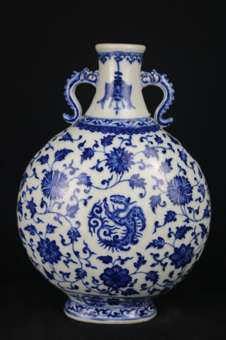Chinese Blue and White Porcelain Moon Flask Vase: Chinese blue and white porcelain moon flask vase; flanked with dragon shape handle; painted with dragon and floral; six character Qianlong mark on base; H: 30 cm, W: 23 cm