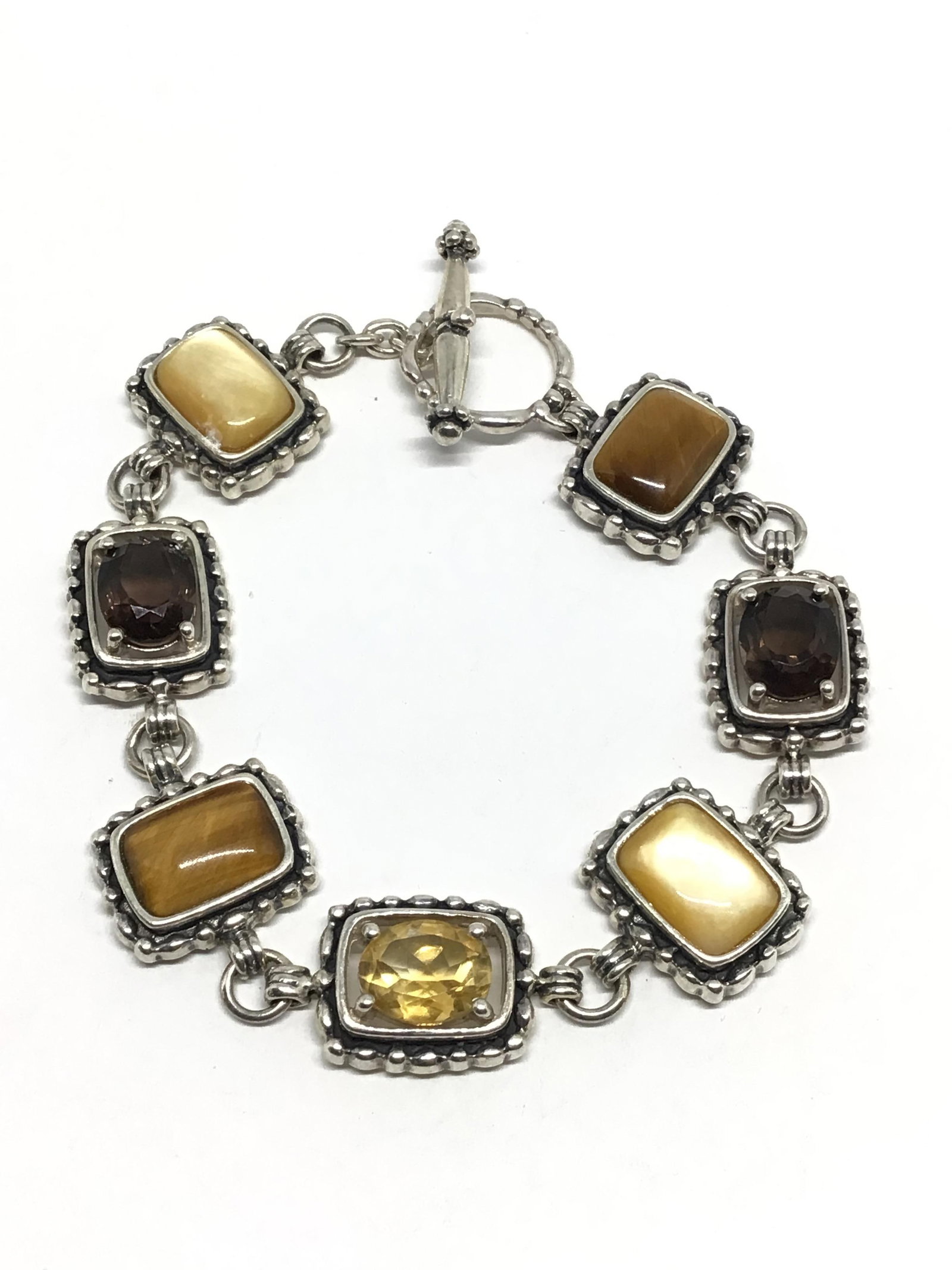 Sterling Silver bracelet: Sterling bracelet with citrine, smoky quartz and tiger eye gemstones. 25.98 grams total weight.
