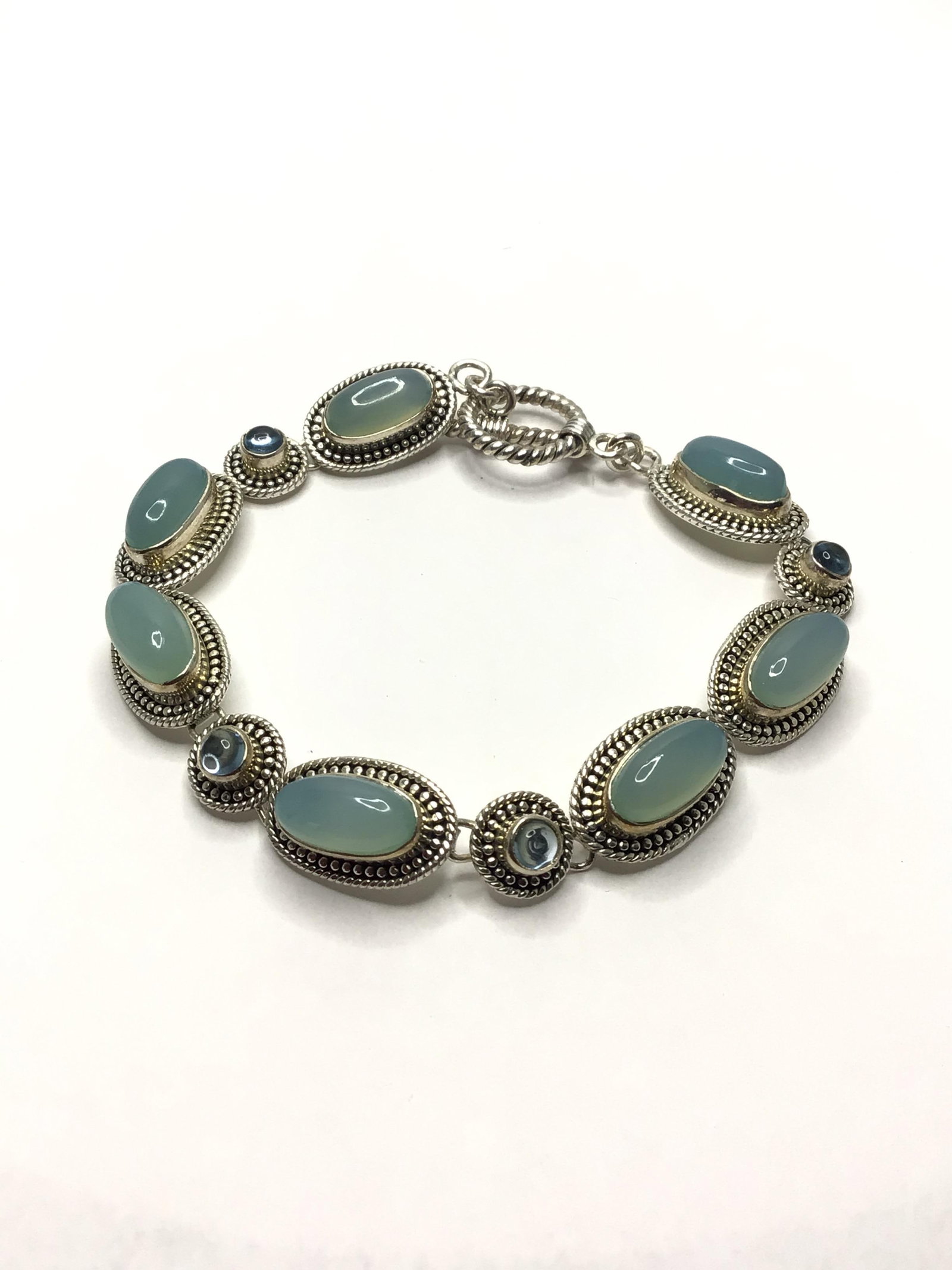 Sterling silver bracelet: Sterling bracelet with moonstone and blue topaz gemstones. 18.88 grams total weight. 7.5 inches length.