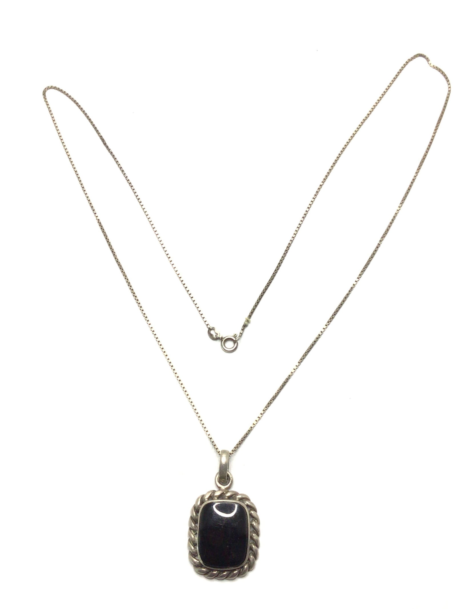 Southwest style necklace and pendant: Sterling silver necklace with pendant featuring onyx stone. 9.96 grams total weight. 24 inch length. 1.95 per gram