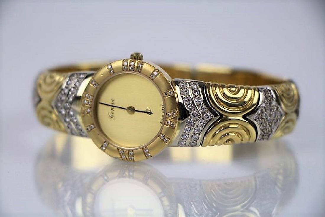 LADY'S 18K GOLD GENEVE WRIST WATCH: 18k yellow and white gold bangle style quartz wrist watch set with 36 full cut diamonds totaling 0.36 ct. and having a yellow and white gold band set with 80 full cut diamonds. The mechanical conditio