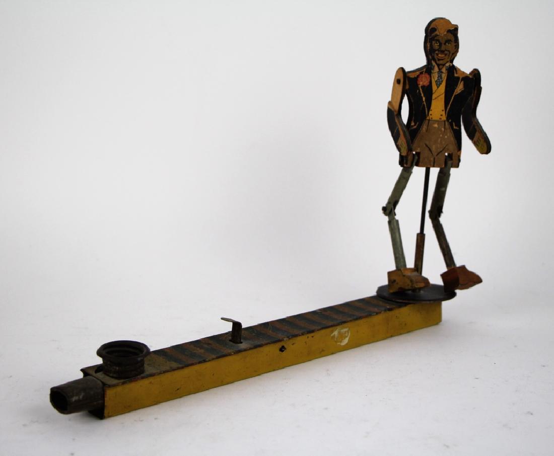 MUSICAL JIGGER VINTAGE TOY: Wood and tin with built in kazoo and lever to make figure dance. Note, some loss to wood on arm and loss paper (see photos). L. 29 cm (11 1/2 inches). Total weight approx. 160 g.