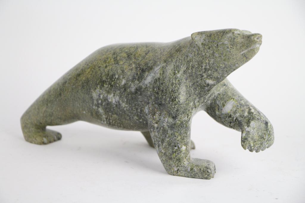 INUIT SOAPSTONE CARVING OF POLAR BEAR: With original sticker, made in Canada. Unsigned. Length: 28 cm. (11 in.) Approx. weight: 3 kg.