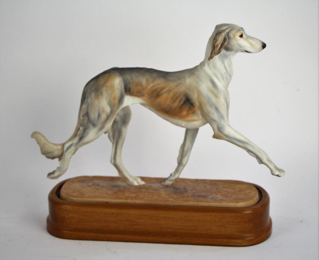 ROYAL WORCESTER DOG "SALUKI": Designed by Doris Lindner. Sitting on fitted wood stand, signed on base with certificate. Numbered 18 / 1000. Length 26 cm. ( 10 in.,) Approx. weight 700 g.