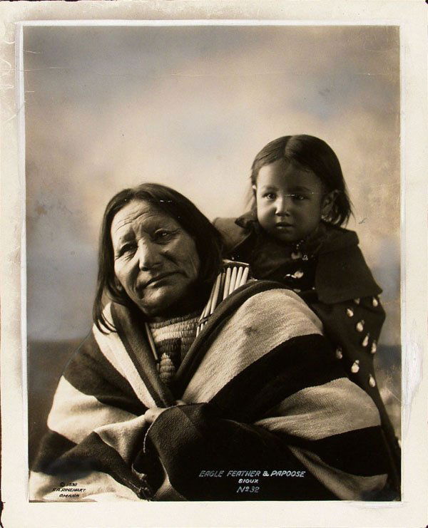 F.A. RINEHART (American) Vintage platinum print: F.A. Rinehart (American, 1861 - 1928) Eagle Feather and Papoose - Sioux. Vintage platinum print. 1898. Printed 1898. Signed, titled and annotated in the negative. 8 7/8 x 7 in. (225 x 178 mm).