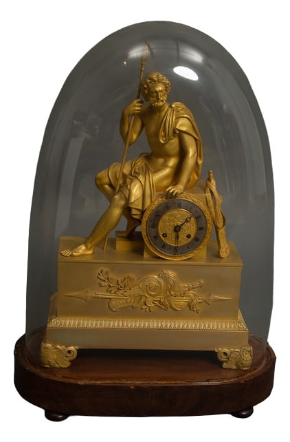 Clock with Ulysses in Patinated Gilt Bronze, 1810: Immerse yourself in the epic of Ulysses with a French Empire gilded bronze clock, a tribute to Homer's OdysseyThe clock rests on zoomorphic feet formed by owls and snakes, adding a touch of mystery