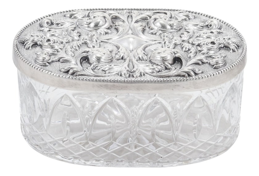 Crystal and Silver Box from Topazio, 1985: Crystal and sterling silver box by Topazio. Faceted crystal, silver lid, profuse embossed decoration of vegetal scrolls. Indication of the Topazio trademark. 7x14x9 cm. Silver. Eagle hallmark
