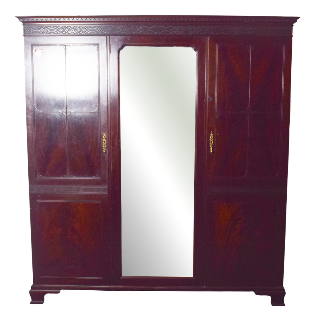 English Mahogany Wardrobe with Mirror, 1910: This elegant English wardrobe exudes timeless charm and practical functionality. Crafted from richly toned mahogany, it features three doors, with the central door adorned by a large mirror that