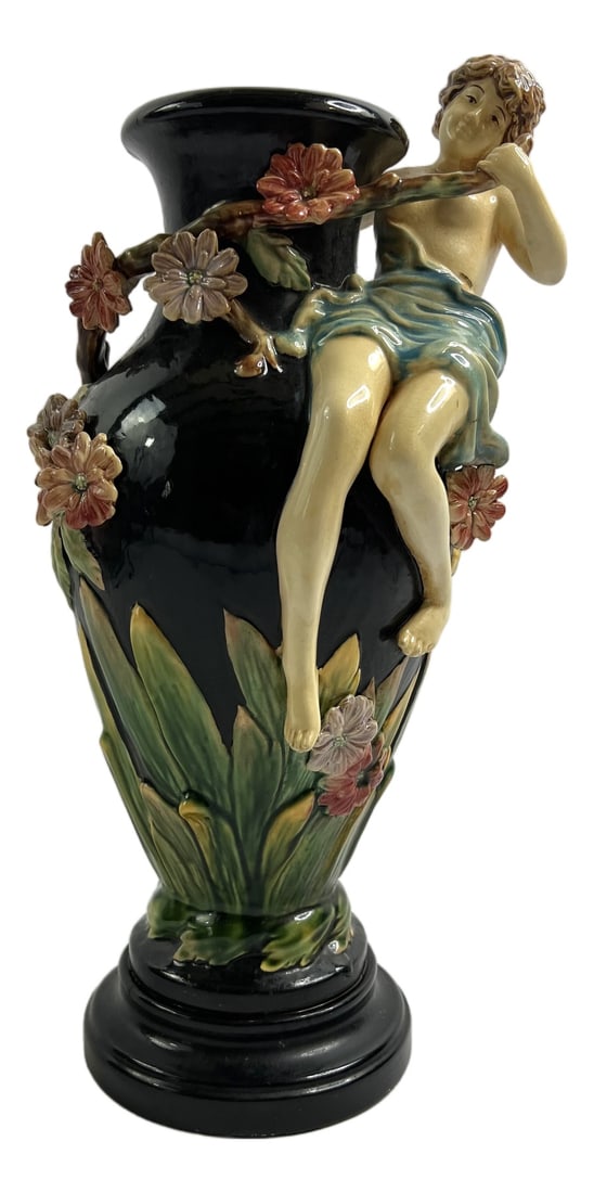 Barbotine Vase with Female Figure from GL Lorraine: This large slipware vase, signed GL Lorraine, unfolds like a living scene frozen in the brilliance of the glazes.A young woman, sculpted in high relief, appears suspended from a flowering branch, her
