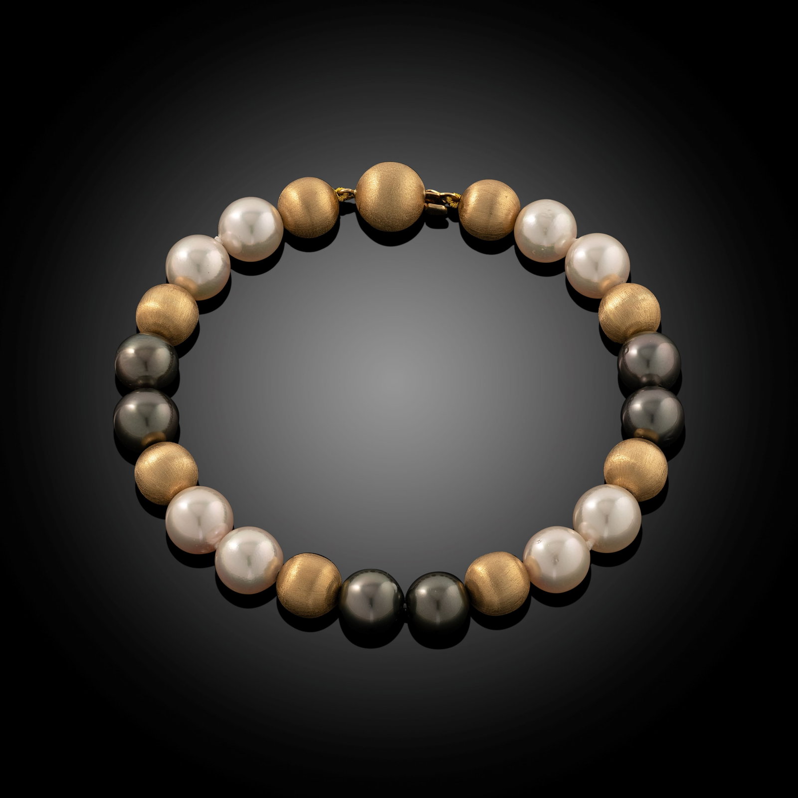 18 Carat Satin Gold Tahitian Pearl Bracelet: 18 carat yellow gold satin finish bead and Tahitian pearl bracelet with ball clasp Length 8" Metal Type: 18ct Yellow Gold Pearl Type: Tahitian Pearl Size: 8.0-9mm Diamond Weight: N/A Condition: Unworn