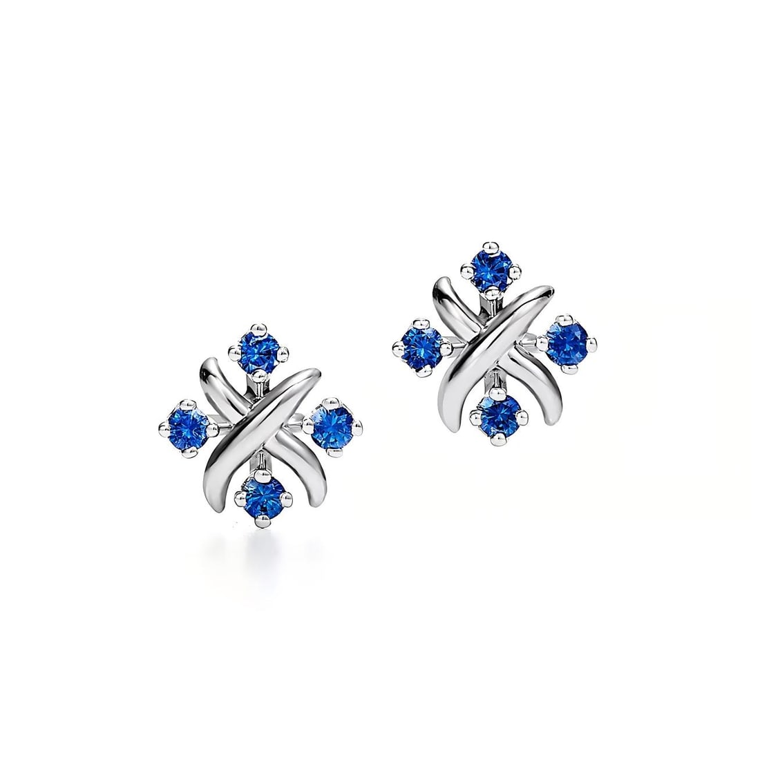 BLUE SAPPHIRE AND DIAMOND STYLE CROSS MOTIF STUD EARRINGS: BLUE SAPPHIRE AND DIAMOND STYLE CROSS MOTIF STUD EARRINGS Description: The lot consists of a pair of stud earrings crafted in white metal and designed in a cross-inspired motif; each earring features