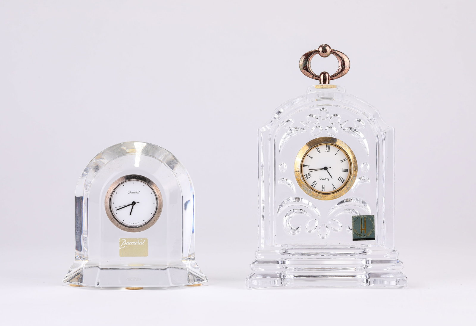 A BACCARAT CRYSTAL CLOCK: A BACCARAT CRYSTAL CLOCK Description: Dimensions: Length: 8.5 cm x Width: 4.4 cm x Height: 8.4 cm. Length: 9.2 cm x Width: 4.2 cm x Height: 14 cm. All measurements are approximate.