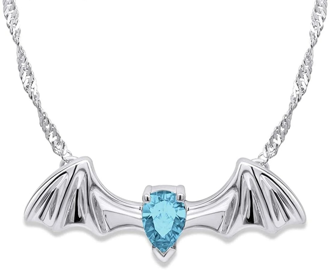 STERLING SILVER-STYLE BAT WING PENDANT NECKLACE WITH BLUE HEART-CUT STONE: STERLING SILVER-STYLE BAT WING PENDANT NECKLACE WITH BLUE HEART-CUT STONE Description: A dramatic bat-wing pendant in bright white metal, centered by a vivid blue heart-cut stone. The reverse bears a