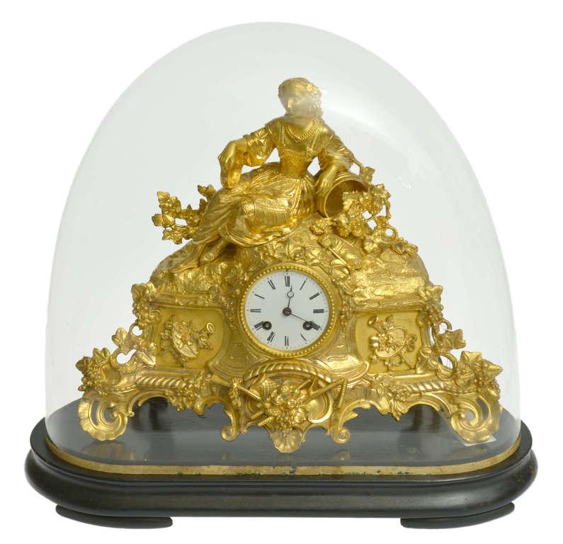 Fireplace clock on a wooden base with a glass dome: France. Gilded bronze. Clock width 40 cm. height 35 cm