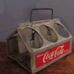 88. Aluminum 6 Pack Coca-Cola Carrier: This 1950s Coca-Cola carrier reads: "Delicious Coca-Cola Refreshing". The handle slides up and down upon movement. It was made for 25 cent Cokes of the day. In today's world, these make fun carrying c