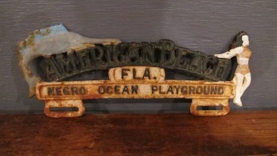 178. "American Beach" License Topper: American Beach, Florida is a historic beach community that during the days of segregation and Jim Crowe, was designated for African-Americans only. This is a cast iron auto license topper, originally