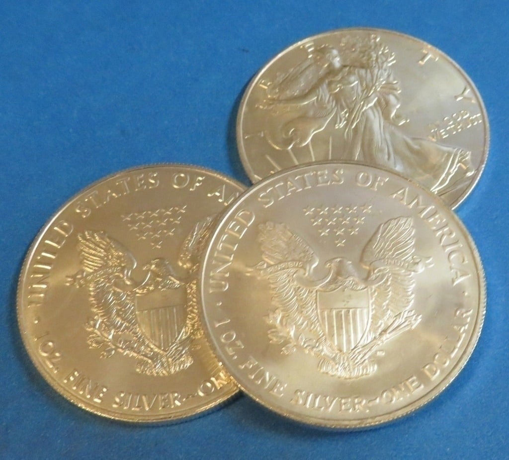 (3) Random Date US Silver Eagles: Items will be as shown in the image- A mixed date and grade lot. Please review the entire terms and conditions prior to placing any bids-