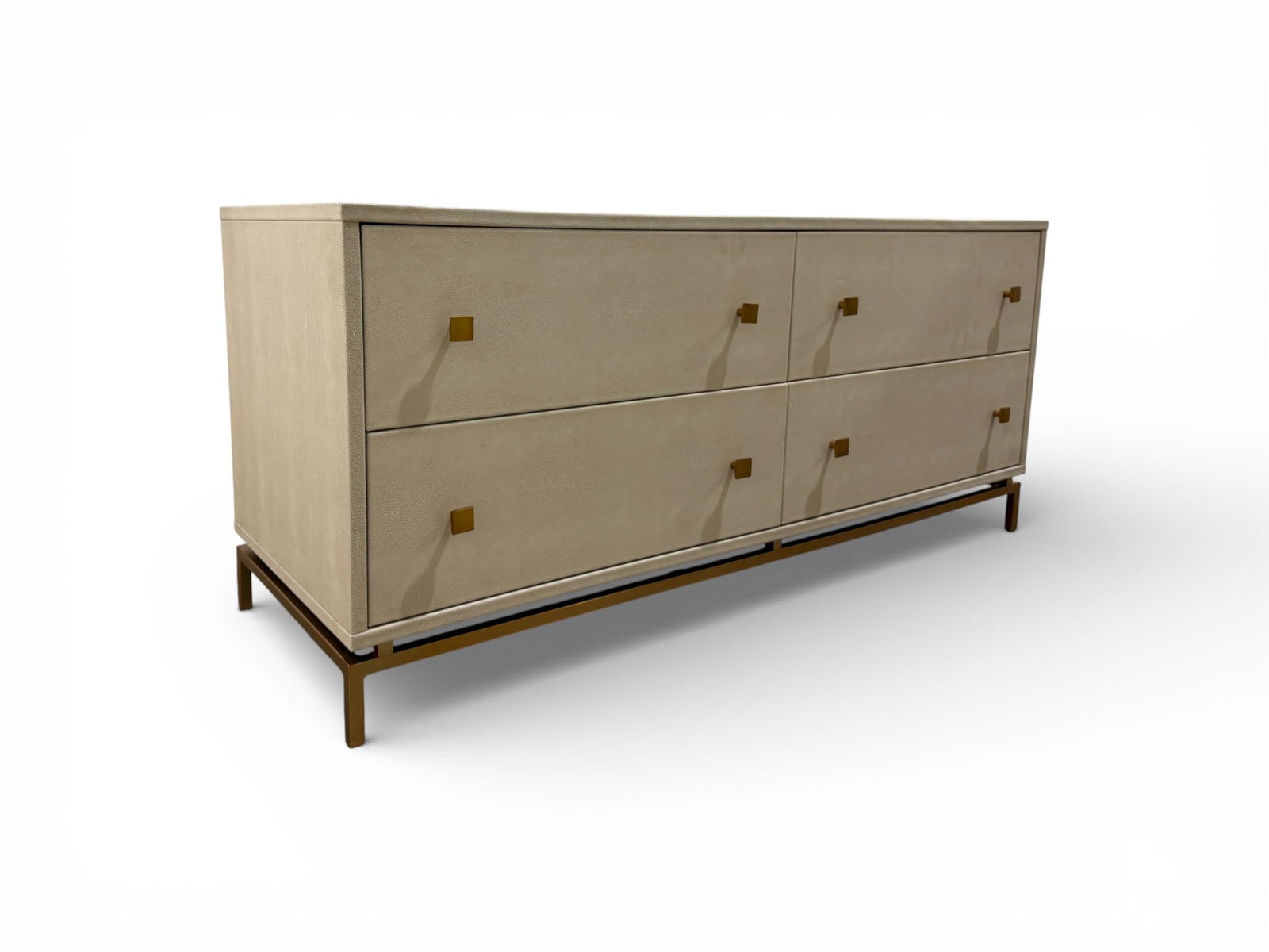 CB2 Shagreen 4-Drawer Dresser: An ivory shagreen boudoir-level dresser on a minimal modern frame. The low profile dresser is completely wrapped in faux embossed sharkskin-like shagreen. Four deep drawers on metal glides with