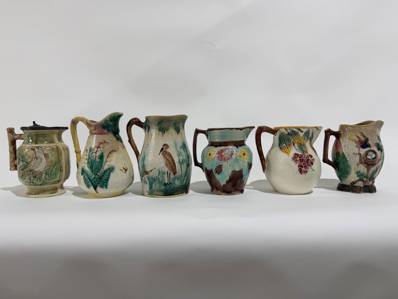 6 Large Vintage Majolica Ceramic Pitchers: A group of 6 large hand painted vintage ceramic Majolica pitchers