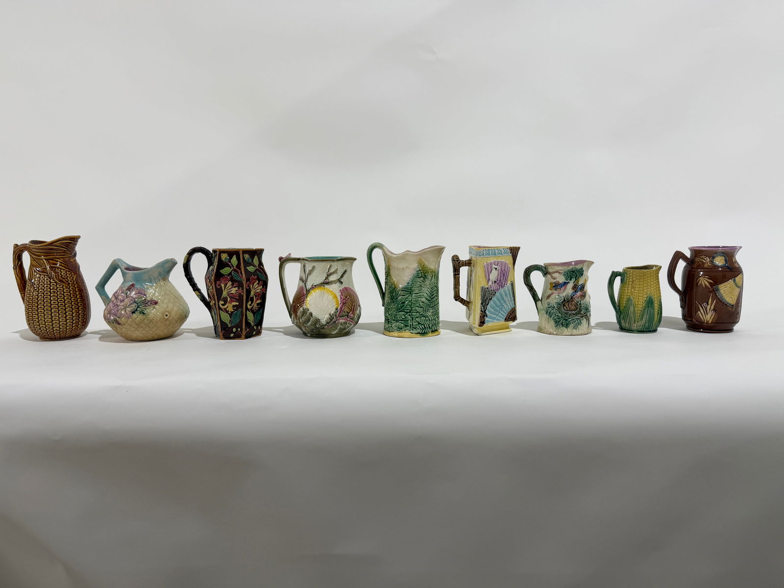 9 Assorted Vintage Majolica Pitchers: A group of 9 assorted vintage Majolica pitchers