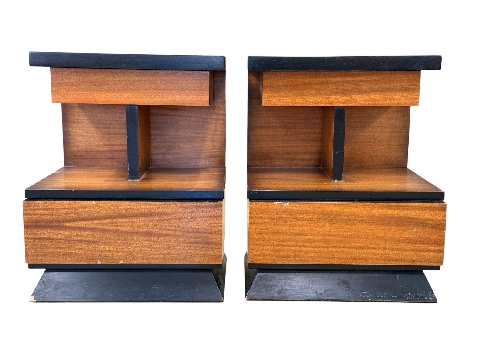 Huntley Mid Century End Stands - Pair: A pair mid century modern end stands. End stands sit on an architectural style base with a finish that fades from darker around the perimeter to lighter in the center. Has shallow drawer on top and de