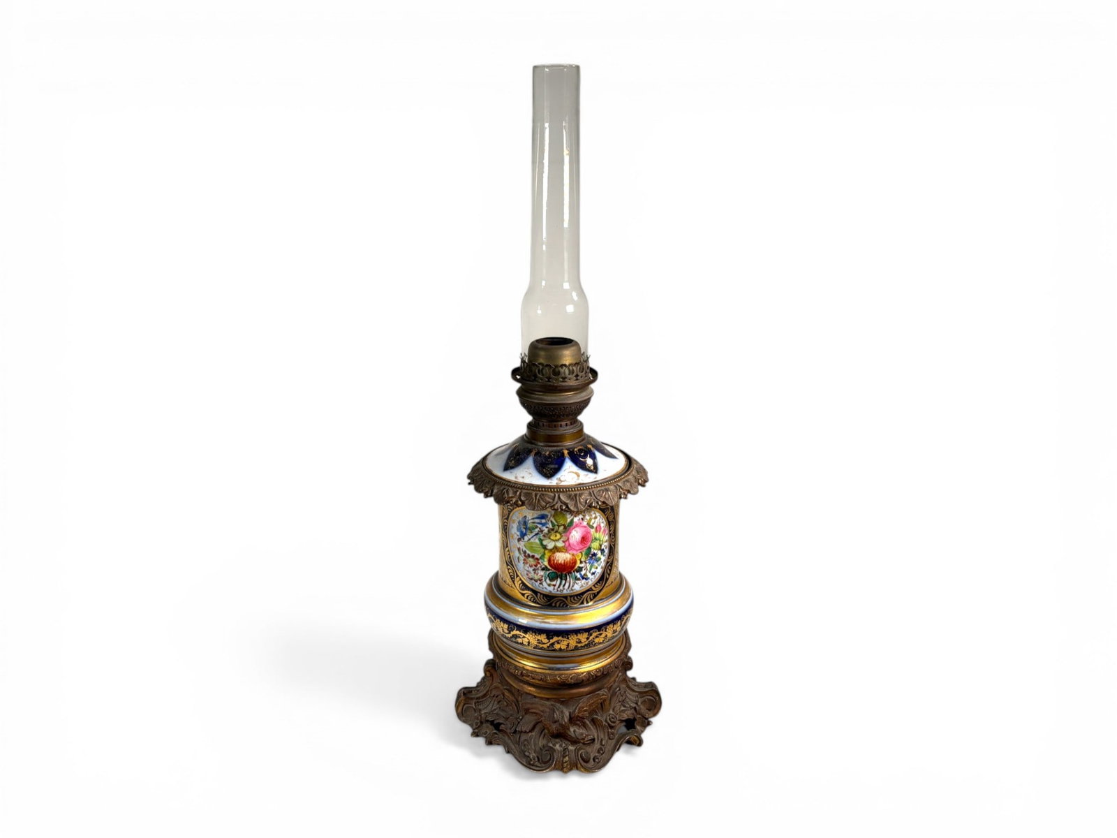 French Porcelain Table Lamp: French porcelain table lamp. Cobalt and gilt with floral decoration on one side and seated woman on the reverse, and gilt metal mounts. Dimensions including chimney: H: 25.25" W: 9" D: 9"