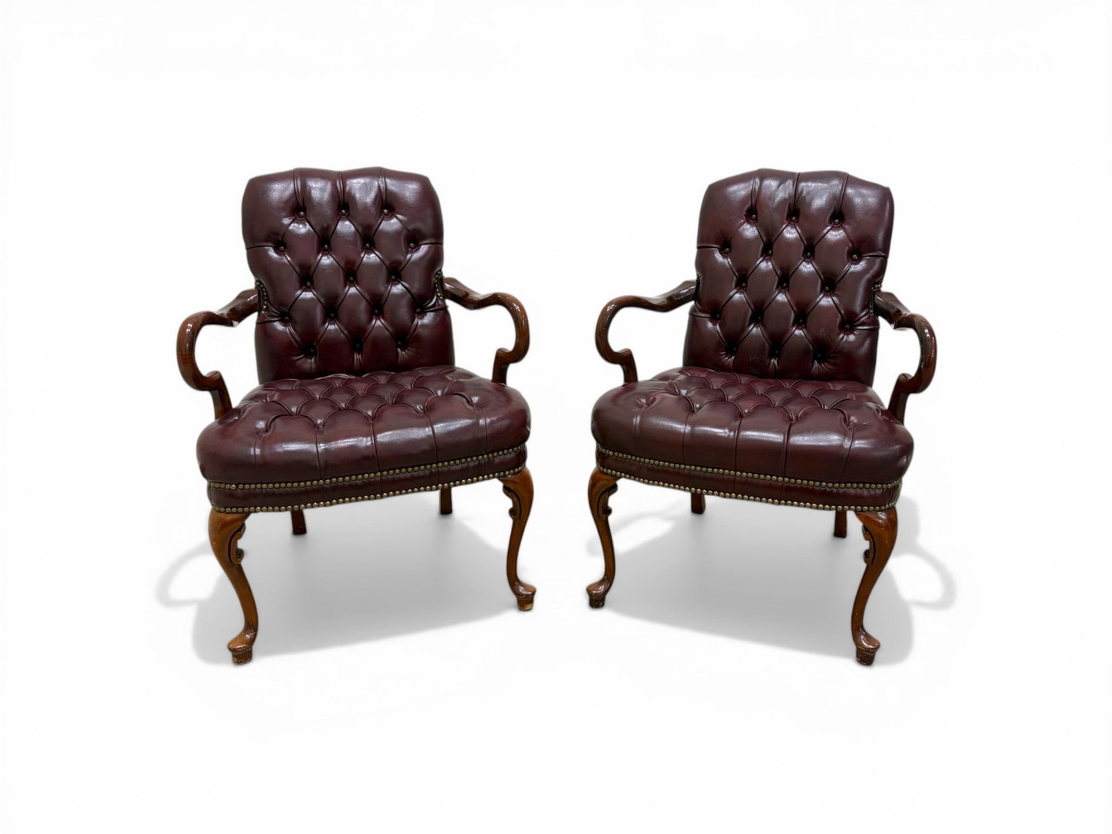 Pair of Chesterfield Armchairs: Pair of Chesterfield armchairs. Dark red leather upholstery, nailhead trim. Dimensions: H: 37" W: 27" D: 28", seat height 19.25"