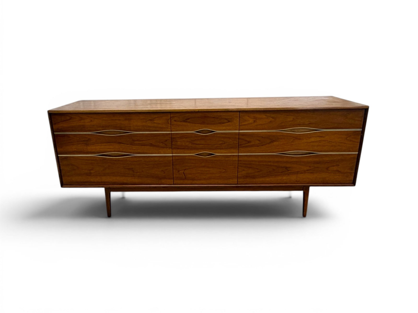 Vignola Walnut & Brass Triple Dresser: Vignola nine drawer triple dresser. Walnut with brass trim. Stamped Roman Furn. Corp, Newark, NJ on drawer interior. Dimensions: H: 31" W: 77.75" D: 19"