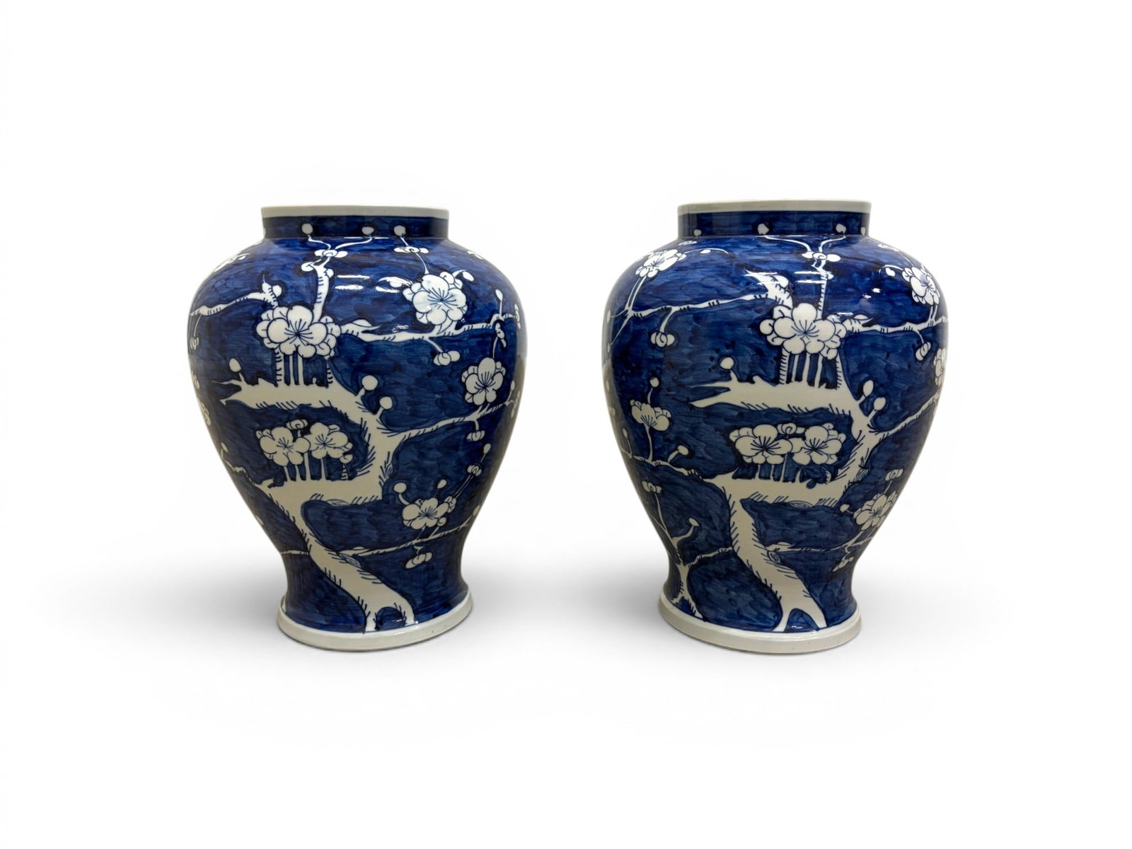 Pair Chinese Porcelain Prunus Vases: Pair of blue and white Chinese porcelain vases, cherry blossom motif. One marked on the underside. Both drilled. Dimensions: H: 13.5" W: 10" D: 10"
