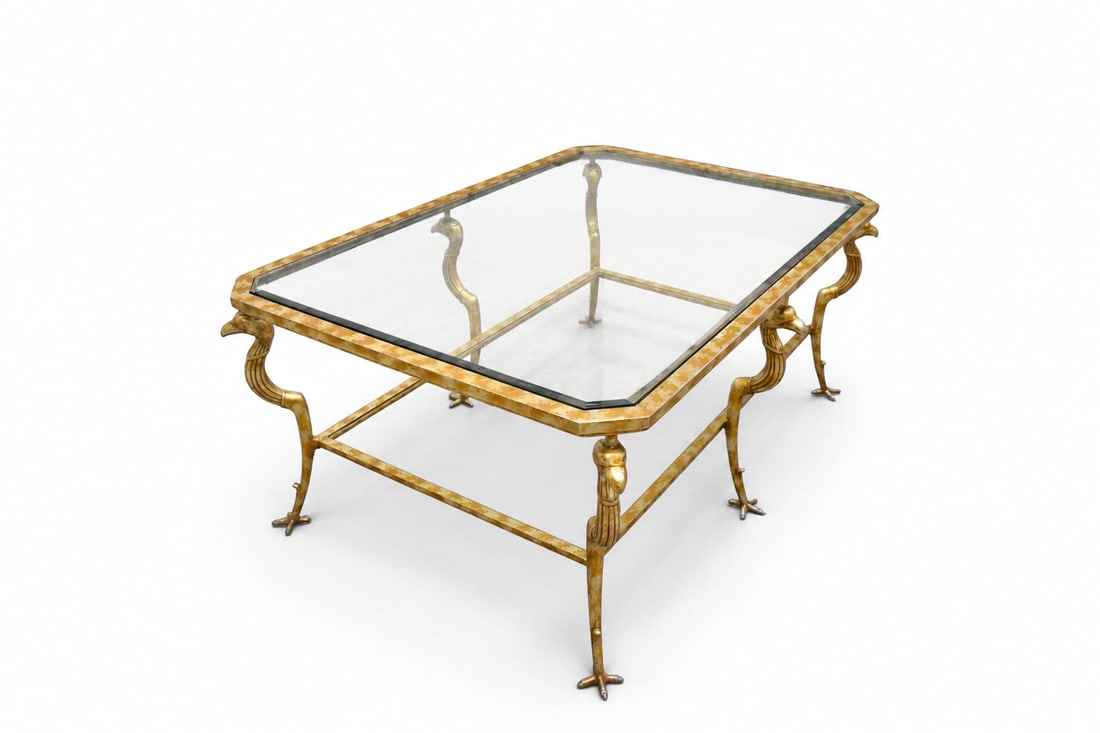 Marge Carson Gilt Metal & Glass Cocktail Table: Marge Carson gilt metal and glass 2 tier cocktail or coffee table. Figural eagle legs with claw feet, beveled glass top. No glass for lower tier. Unmarked. Dimensions: H: 14.5" W: 56.25" D: 38.75"