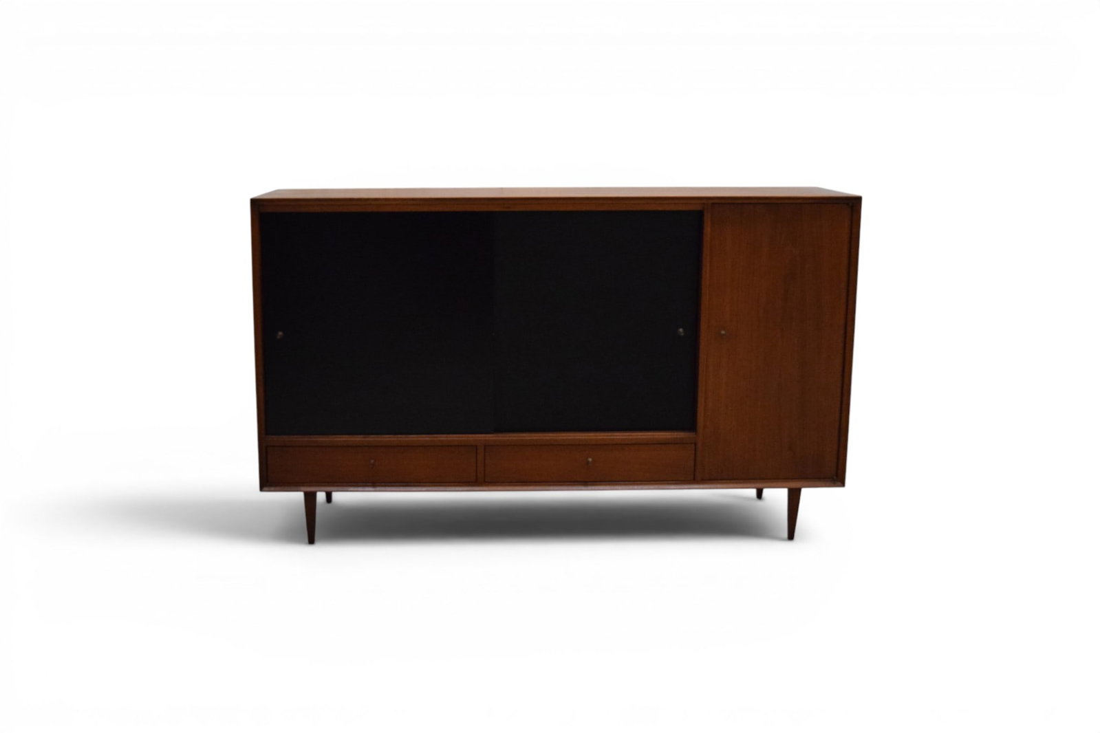 George Nelson Style Credenza: George Nelson style credenza. Walnut, with black plastic doors. 2 sliding doors with interior shelf and 2 drawers below, cabinet door with interior shelf. Unmarked. Dimensions: H: 36.75" W: 60" D: 14"