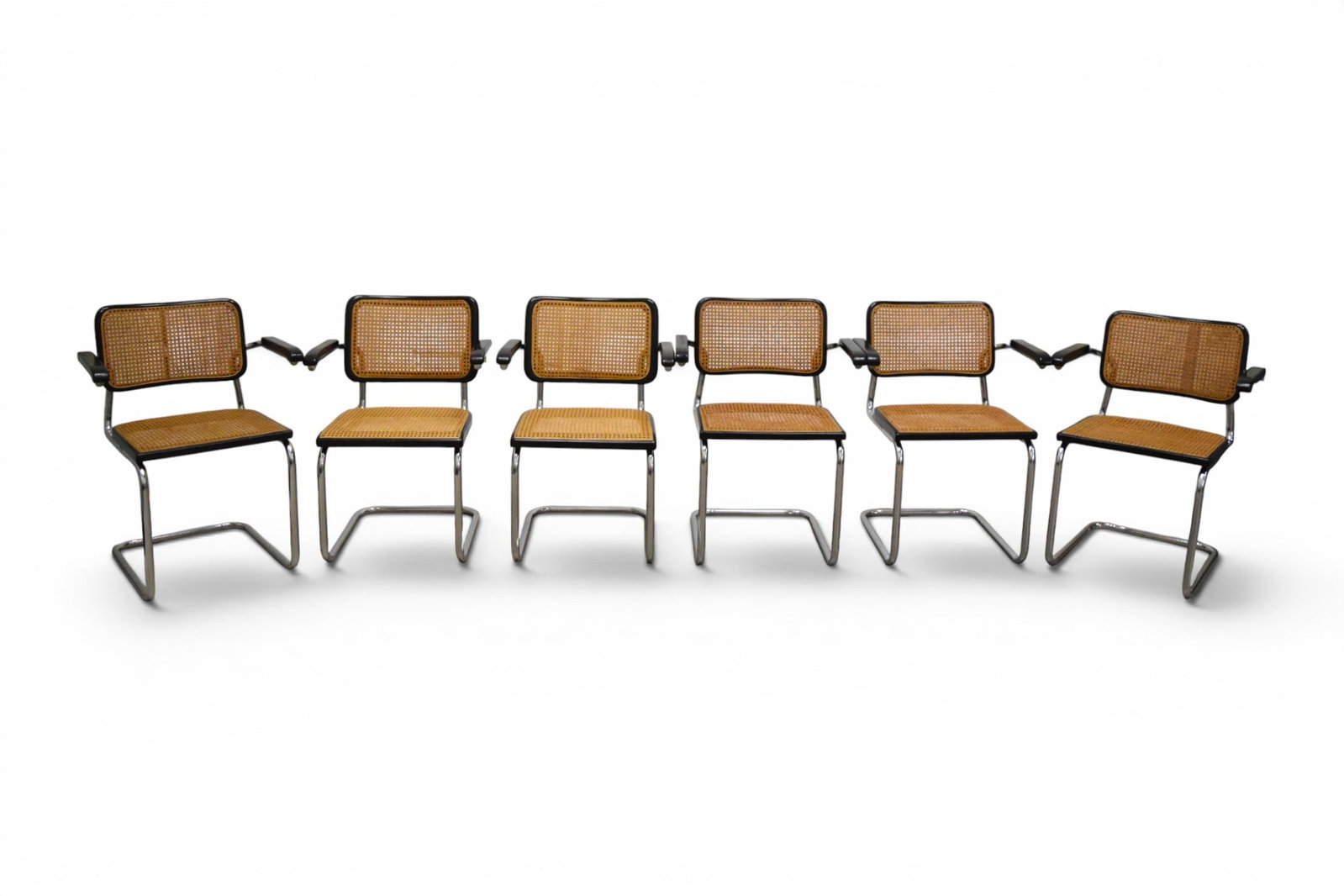 6 Marcel Breuer Cesca Armchairs: Set of 6 Marcel Breuer Cesca armchairs. 3 with Made in Italy labels on the undersides. 2 chairs are slightly shorter than the other 4.. Dimensions: H: 31.5" W: 24" D: 22", seat height 18"