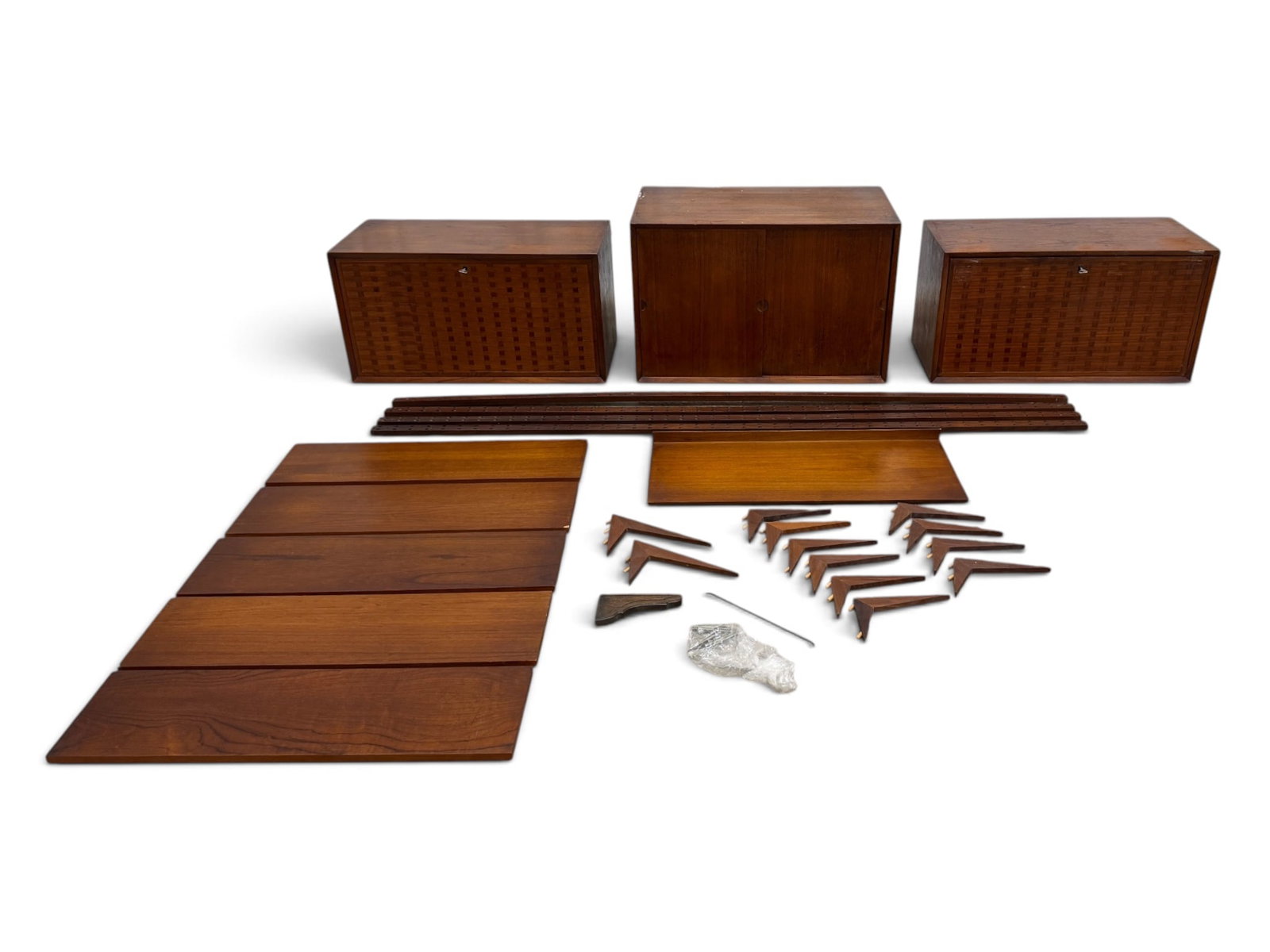 3 Bay Teak Cado Wall Unit: A 3 Bay Teak Cado Wall unit. 3 Cabinets (2 Woven), 6 Shelves (1 Desk Shelf). Brackets included (10 Small, 2 Large) 5 Shelves: H: .75" W:31.5 D:8.75" Desk Shelf: H:2" W:31.5" D:14" 4 Support Beams: