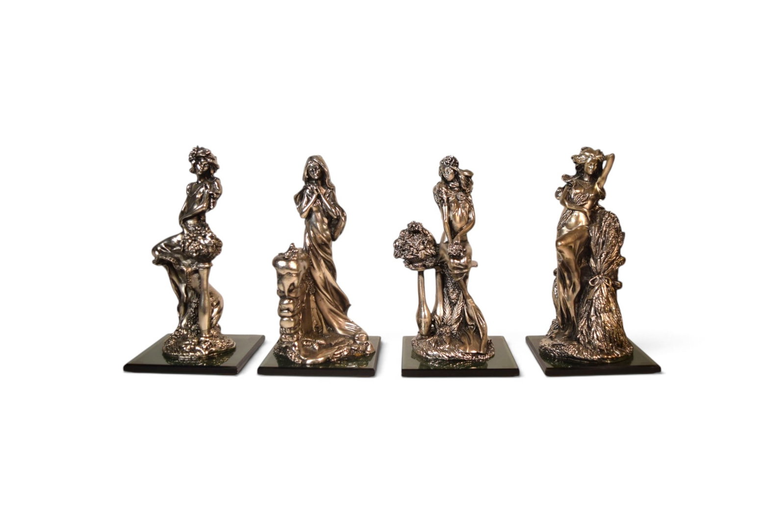 4 Italian Silverplated Four Seasons Sculptures: Set of 4 silverplate "Four Seasons" art nouveau figures, on glass bases. Bases with Made in Italy labels on the undersides, figures with Italian psuedo-800 hallmarks. Dimensions of tallest figure: H:
