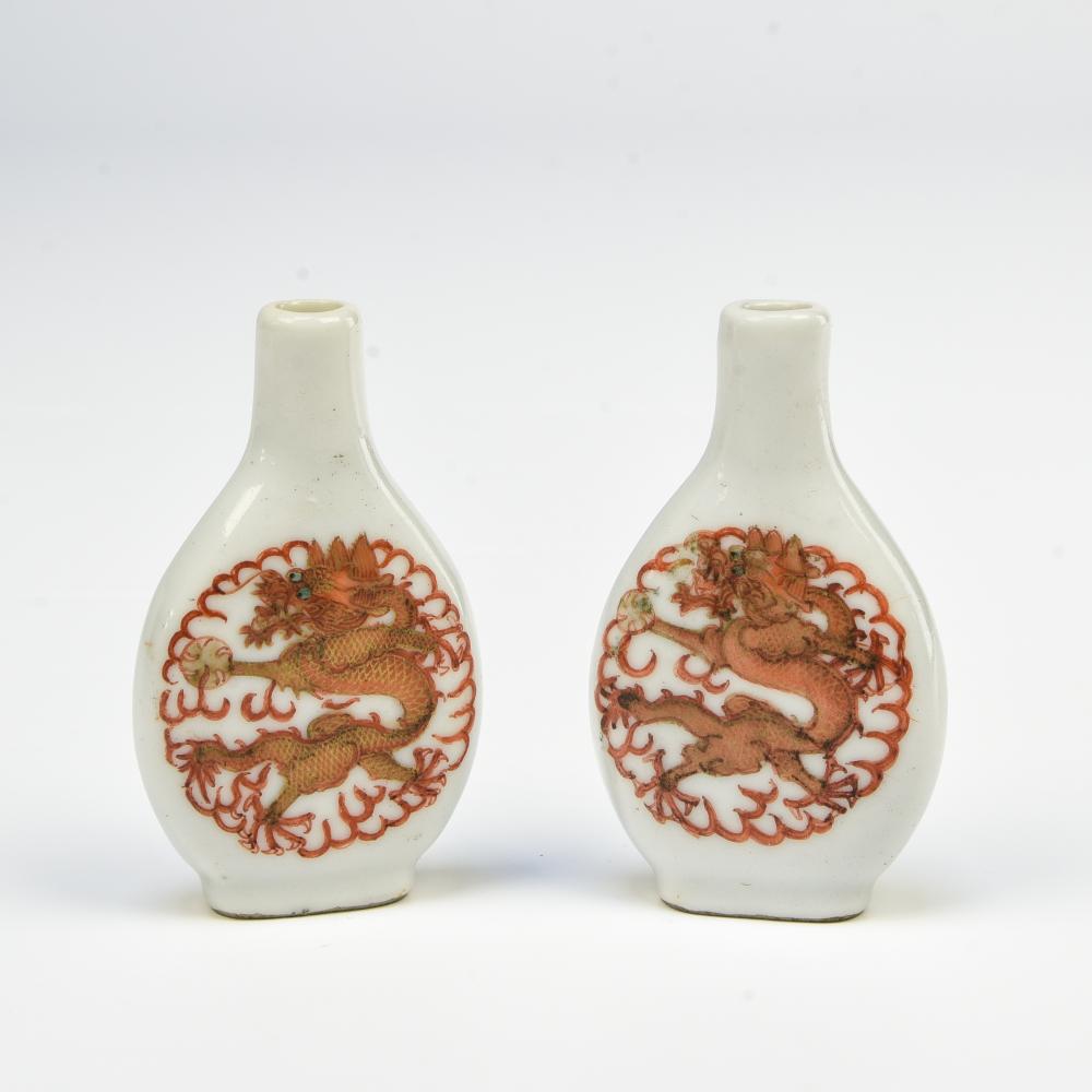 Two baluster snuff flasks: Two baluster snuff flasksCHINA - 20TH CENTURYRust-red and gold enamelled porcelain featuring a dragon chasing the sacred pearl in the clouds. Expert: Cabinet PortierMissing the spoon. H : 7 cm